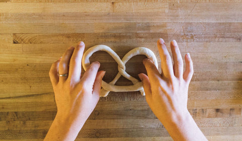 Hands twisting a soft pretzel, photo by Miranda Harple